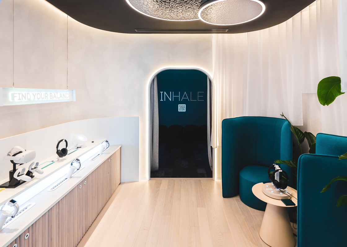 The EE Studio Digital Spa Meditation Zone designed by YourStudio Retail Design Agency featuring doorway and two comfortable seats and the word Inhale in lights