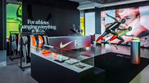 Nike Dream Arena George Street Sydney. Photo displays sprinting athelete mannequins and merchandise display cabinet with large scale digital screens in the background