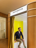 Snap Photobooth Paris, man laughs whilst sitting in a wooden photobooth